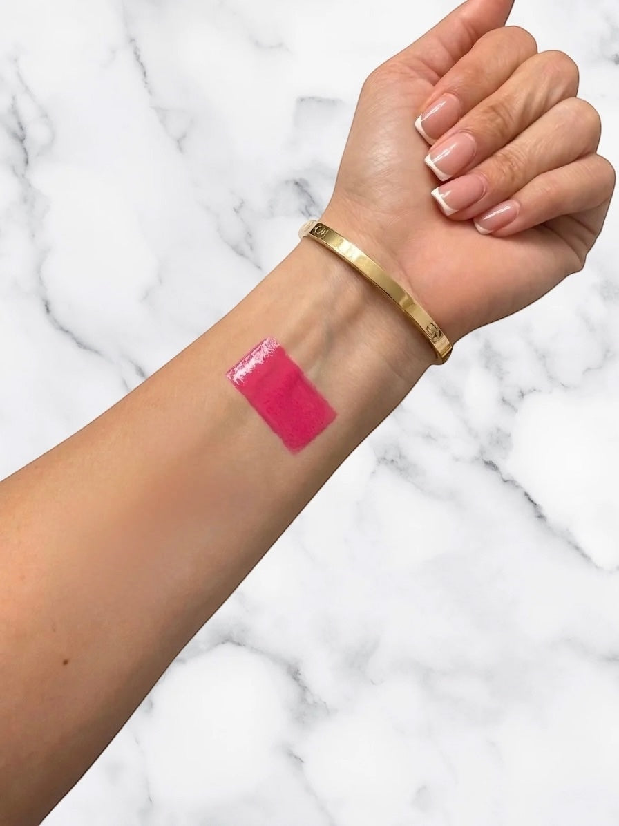 ËNAML Theory The Barbie Edit shade 01B cool pink satin gloss lipstick swatch on a woman's inner wrist