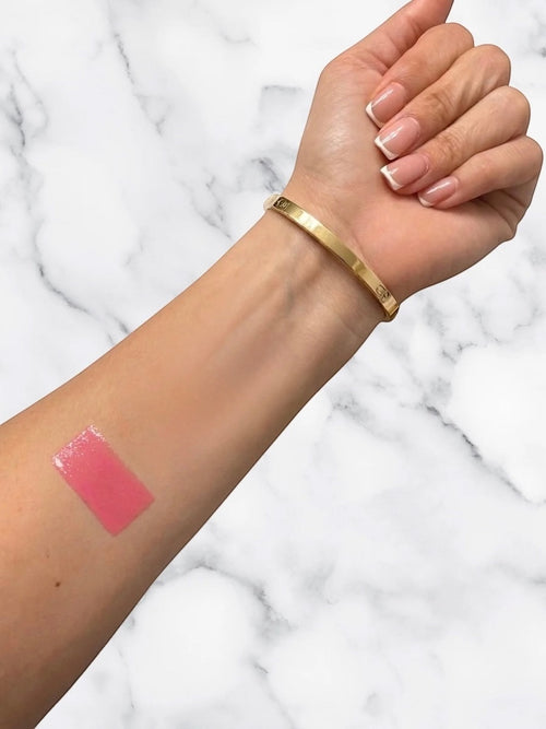 ËNAML Theory Founding Pink shade swatch on a woman's arm, showcasing a sheer cool baby pink smile contrast pigment.